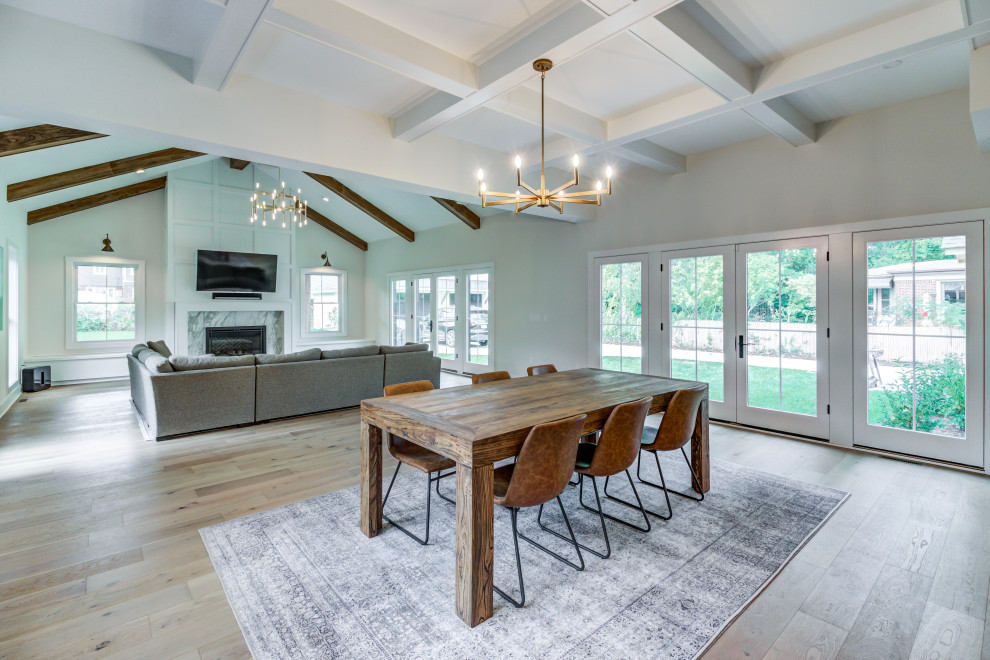 Immagine di una sala da pranzo aperta verso la cucina classica con pareti grigie, parquet chiaro e soffitto a cassettoni