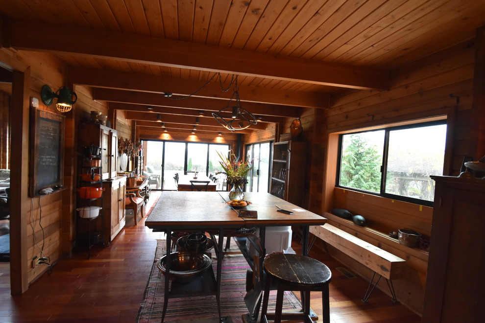 Idee per una sala da pranzo aperta verso la cucina rustica di medie dimensioni con pavimento in legno massello medio e camino ad angolo