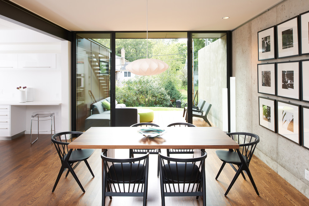 Idée de décoration pour une salle à manger ouverte sur la cuisine minimaliste avec un sol en bois brun.