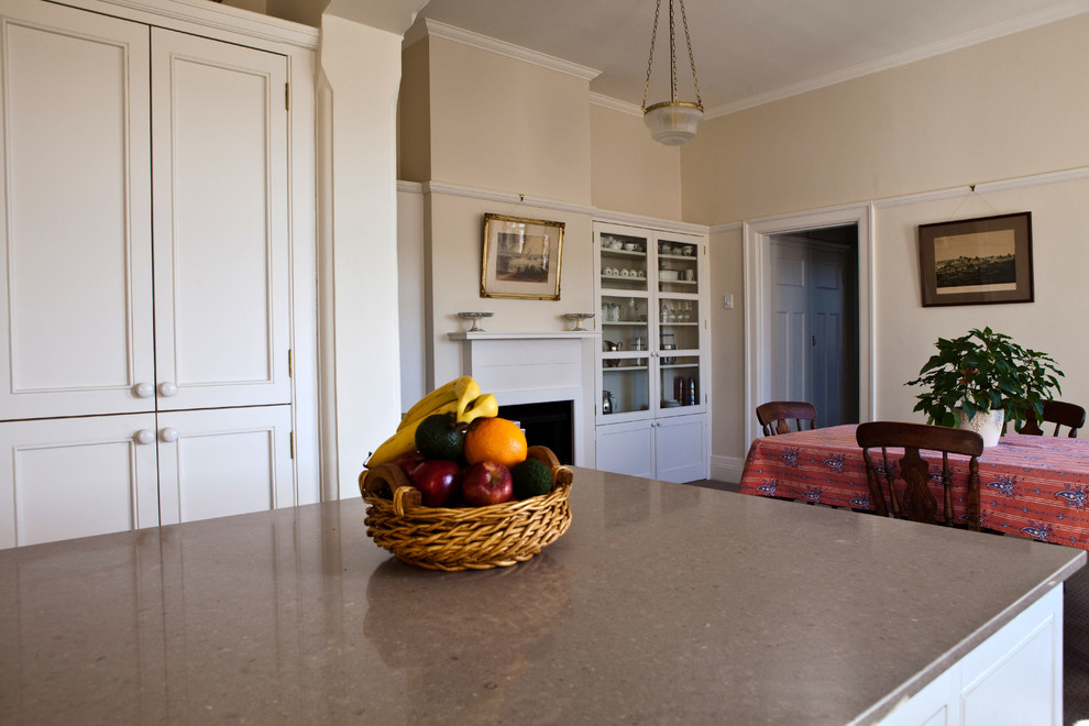 Cette photo montre une petite salle à manger ouverte sur la cuisine craftsman avec un mur blanc, moquette, une cheminée standard, un manteau de cheminée en bois et un sol marron.