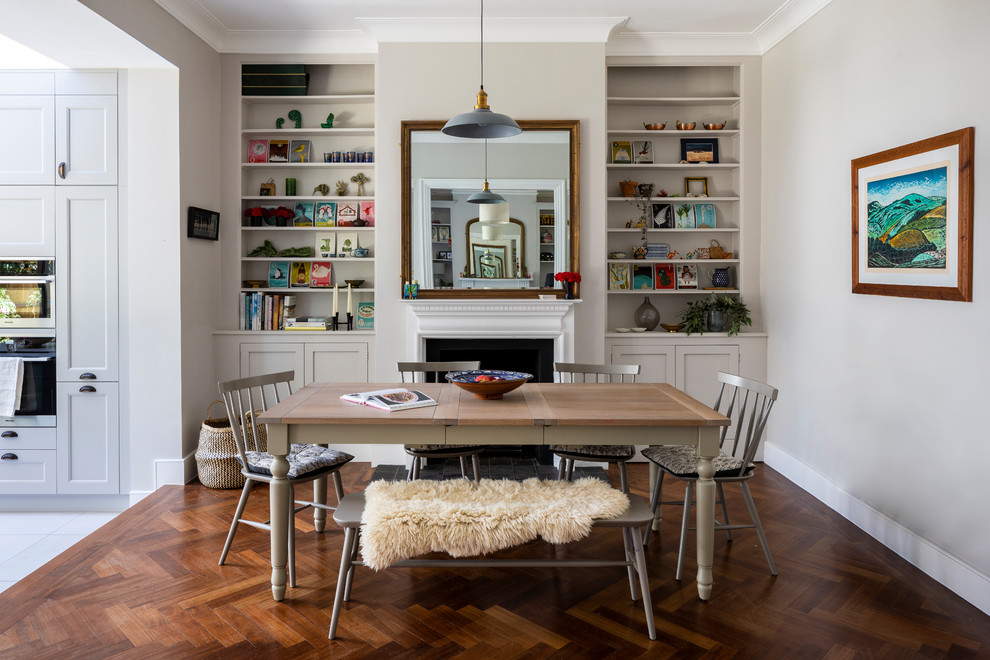 Kleine Moderne Wohnküche mit grauer Wandfarbe, dunklem Holzboden, Kamin, Kaminumrandung aus Metall und braunem Boden in London
