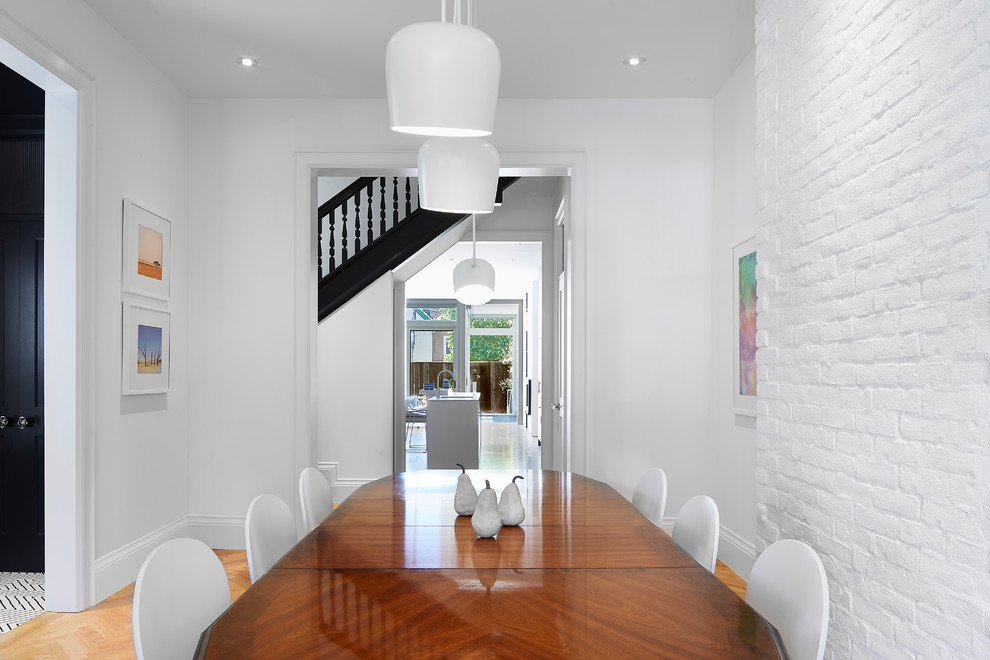 Esempio di una sala da pranzo contemporanea con pareti bianche, pavimento in legno massello medio e pavimento marrone