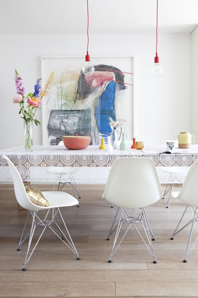 Example of a minimalist light wood floor dining room design in Amsterdam with white walls