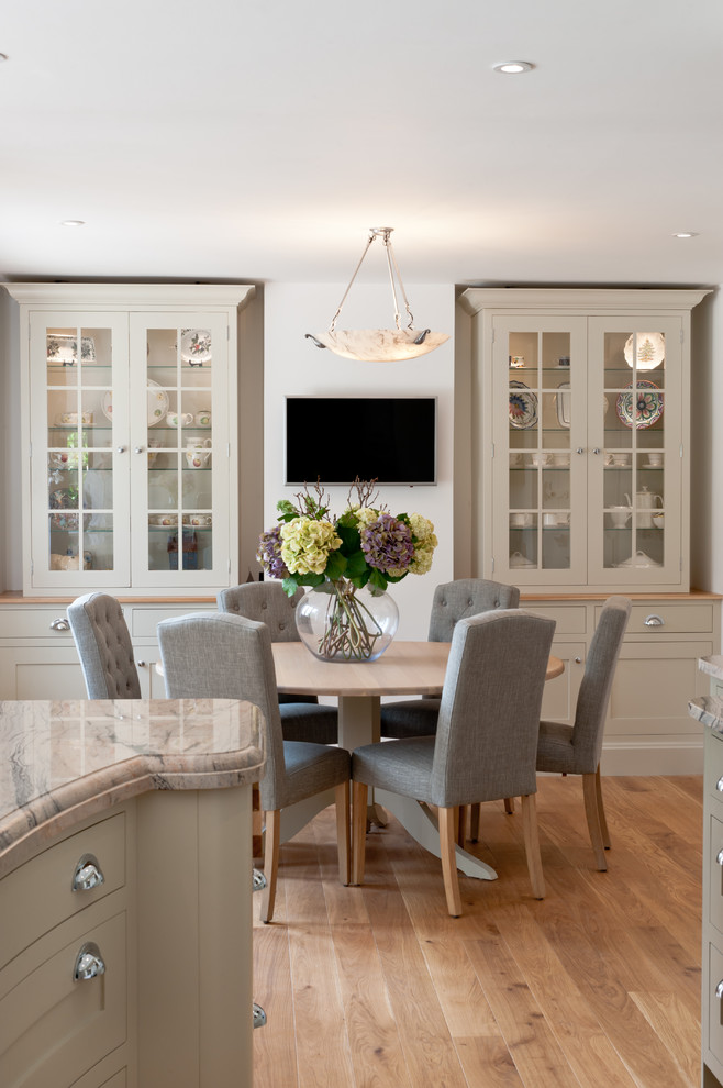 Esempio di una sala da pranzo aperta verso la cucina classica con pareti bianche, parquet chiaro e pavimento marrone
