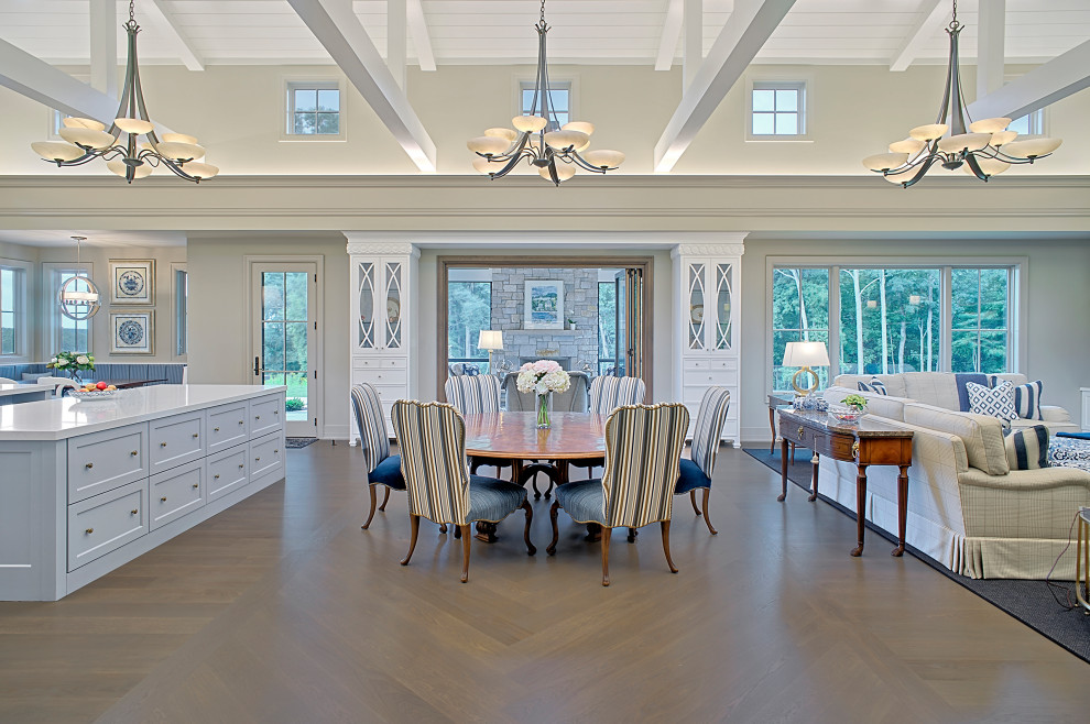 Immagine di un'ampia sala da pranzo aperta verso il soggiorno classica con pareti beige, pavimento in legno massello medio, pavimento marrone e soffitto a volta