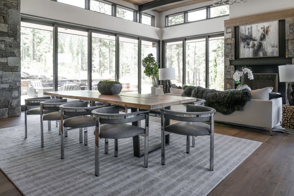 Inspiration for a large contemporary kitchen/dining room in Sacramento with white walls, medium hardwood flooring, a standard fireplace, a stone fireplace surround, brown floors and a wood ceiling.