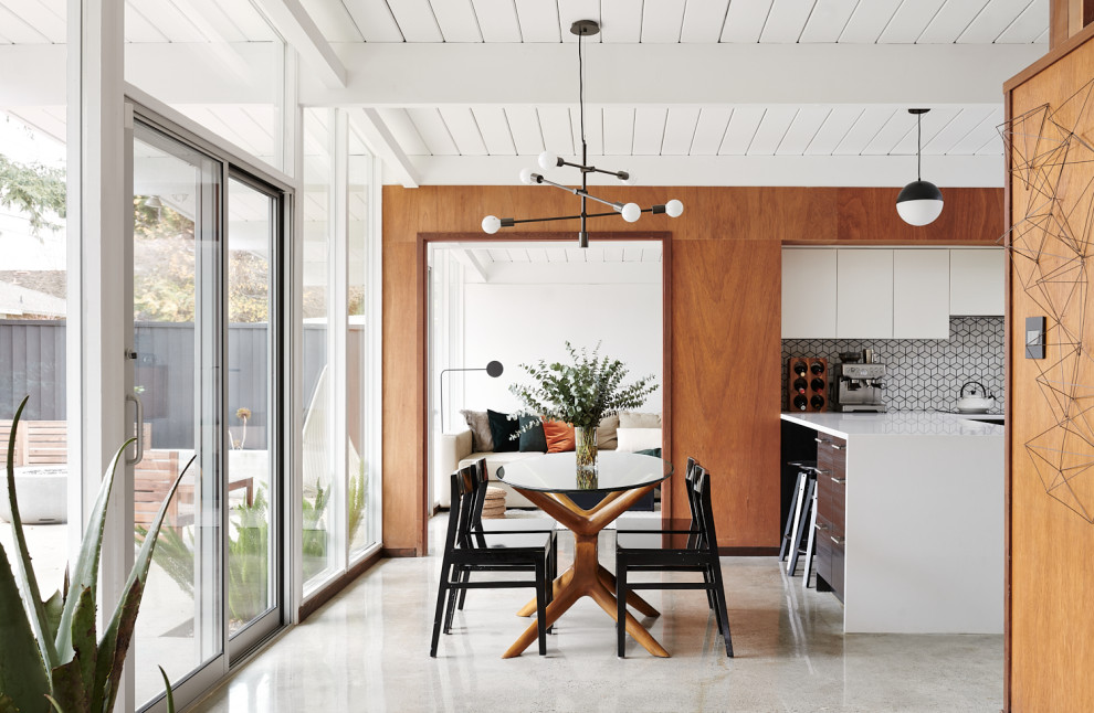 Inspiration for a retro kitchen/dining room in San Francisco with white walls, concrete flooring, grey floors, a timber clad ceiling and a vaulted ceiling.