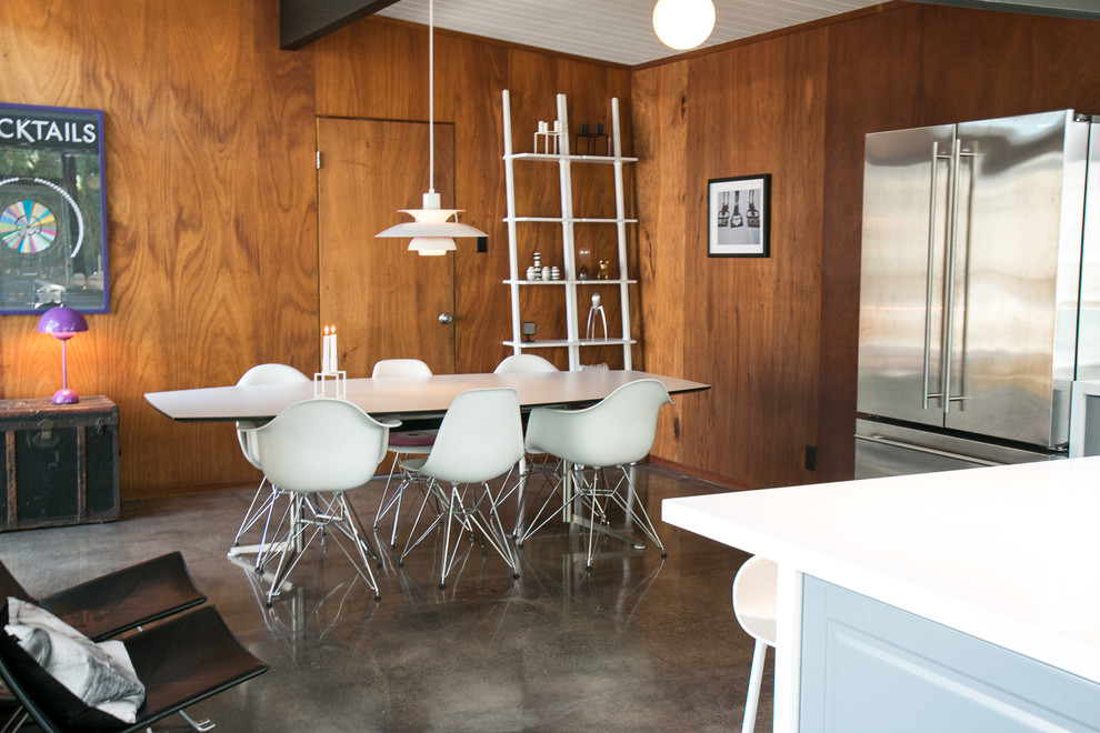 Foto di una sala da pranzo aperta verso la cucina minimalista di medie dimensioni con pareti marroni e pavimento in cemento