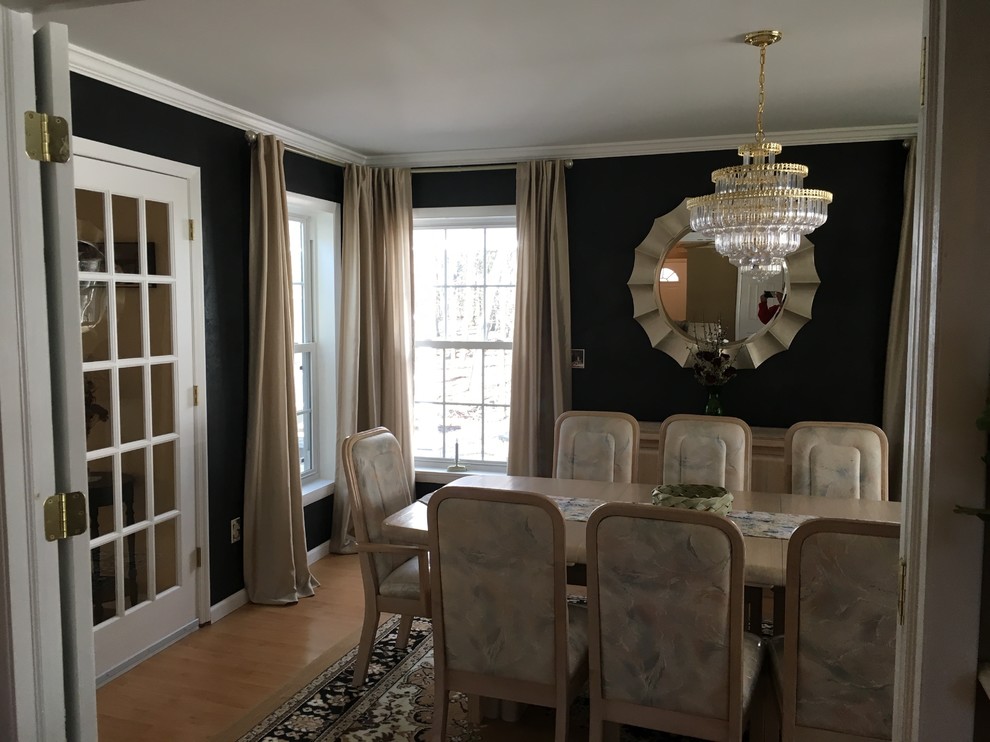 Example of a mid-sized minimalist light wood floor enclosed dining room design in Boston with black walls