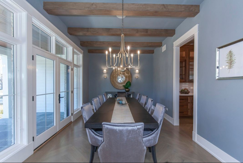 Idee per una grande sala da pranzo country chiusa con pareti blu, parquet chiaro, pavimento marrone e travi a vista