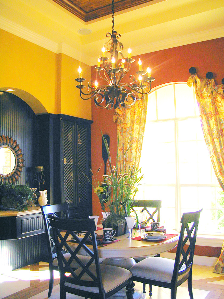 Foto di una sala da pranzo classica chiusa e di medie dimensioni con pareti gialle e pavimento in legno massello medio