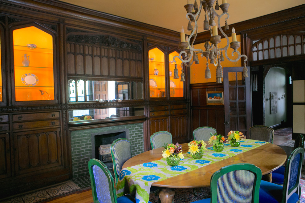 Idee per una sala da pranzo classica chiusa e di medie dimensioni con pareti gialle, parquet chiaro, camino classico e cornice del camino piastrellata