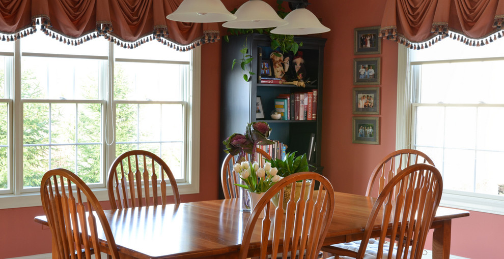 Example of a large classic medium tone wood floor and brown floor kitchen/dining room combo design in Columbus with pink walls and no fireplace