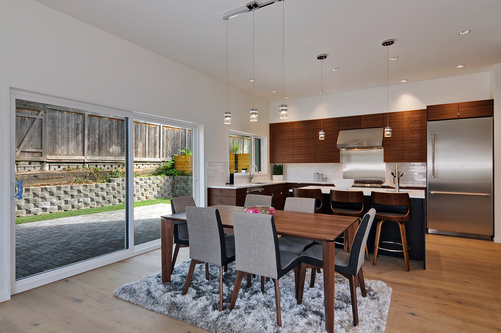 Ispirazione per una sala da pranzo aperta verso la cucina minimalista di medie dimensioni con pareti bianche e pavimento in legno massello medio