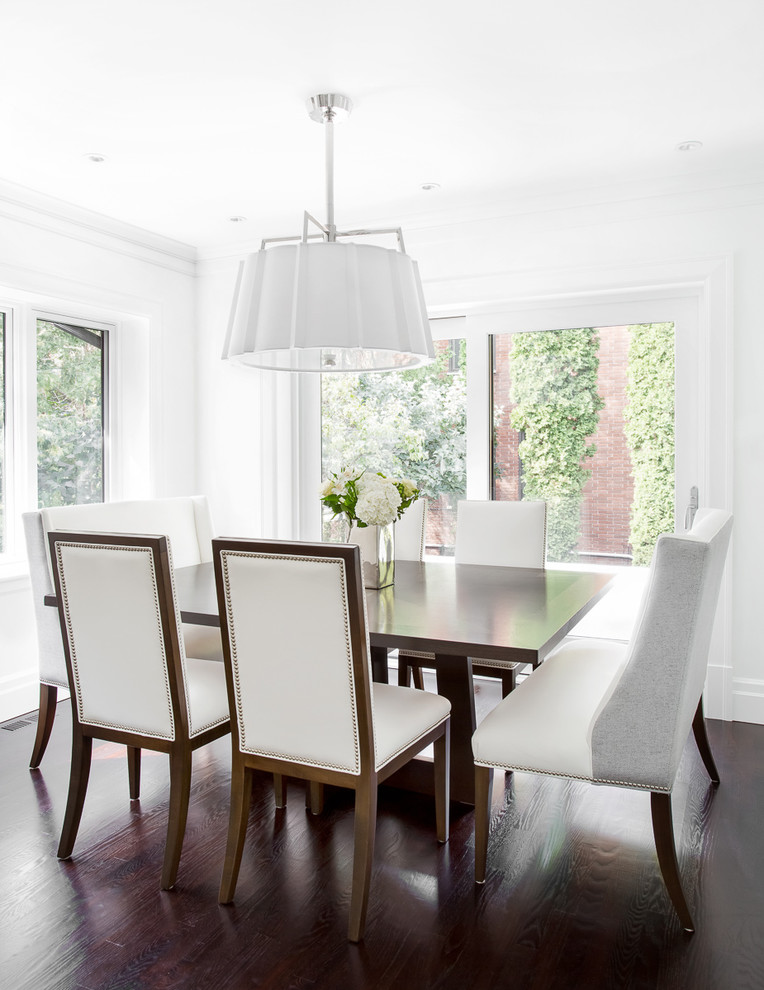 Classic dining room in Montreal with white walls and dark hardwood flooring.