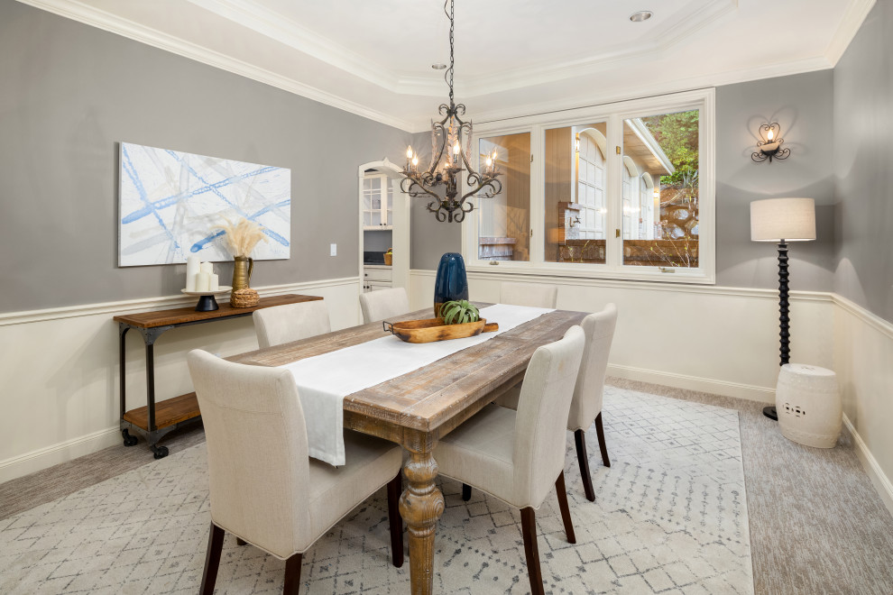 Inspiration for a large transitional carpeted, gray floor, tray ceiling and wainscoting enclosed dining room remodel in Seattle with gray walls