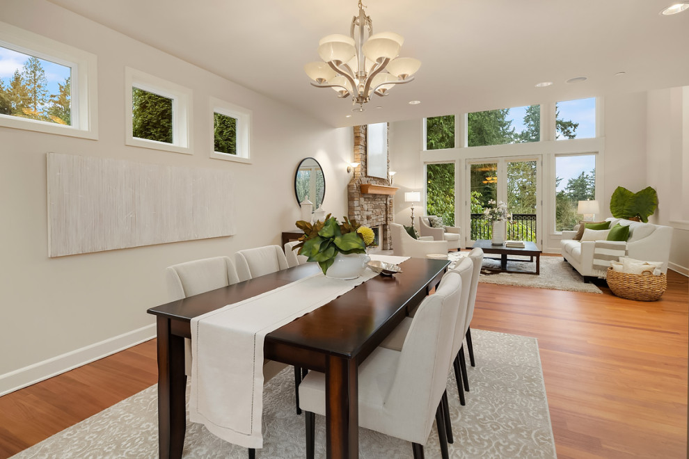 Exemple d'une grande salle à manger ouverte sur le salon chic avec un mur blanc, un sol en bois brun et un sol marron.