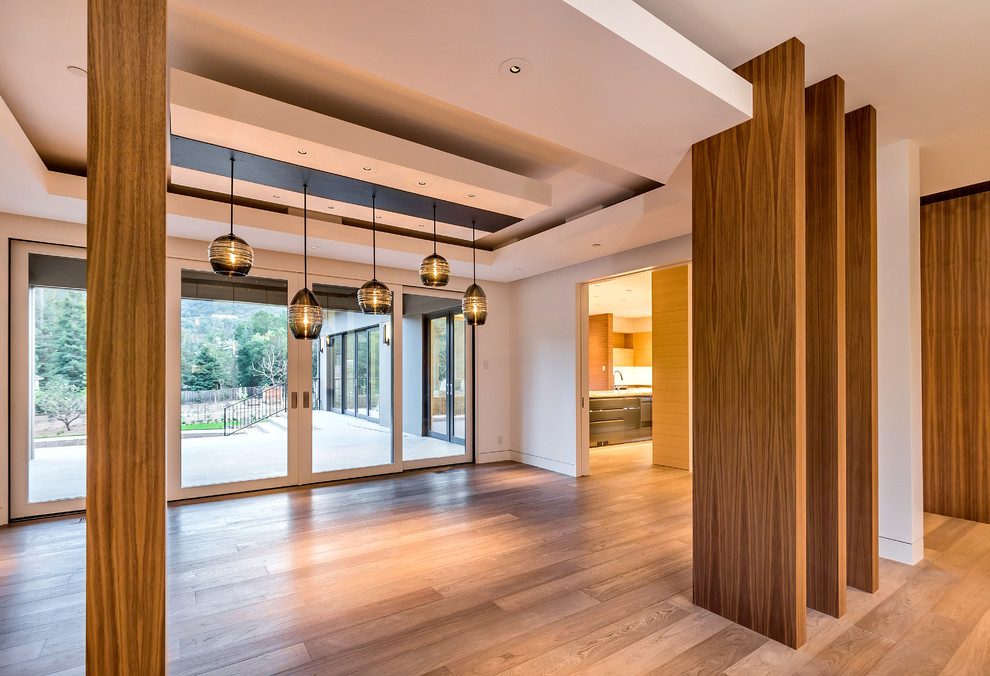 Esempio di un'ampia sala da pranzo aperta verso il soggiorno minimalista con pareti bianche e pavimento in legno massello medio