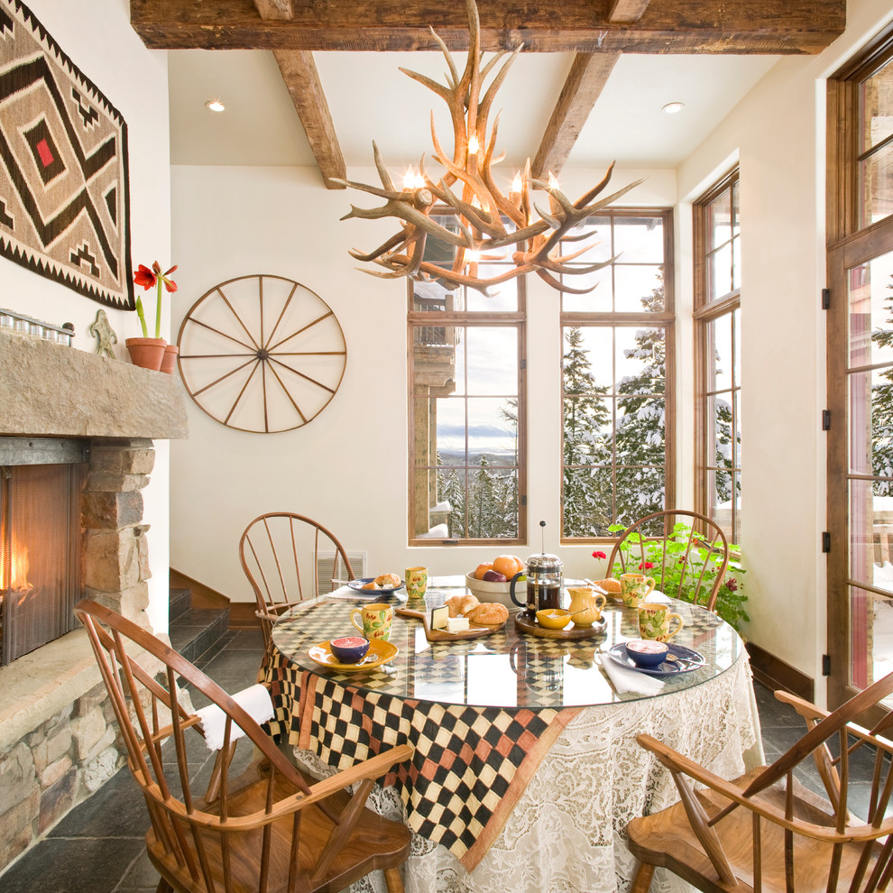 This is an example of a large rustic enclosed dining room in Other with white walls, no fireplace, ceramic flooring and a stone fireplace surround.