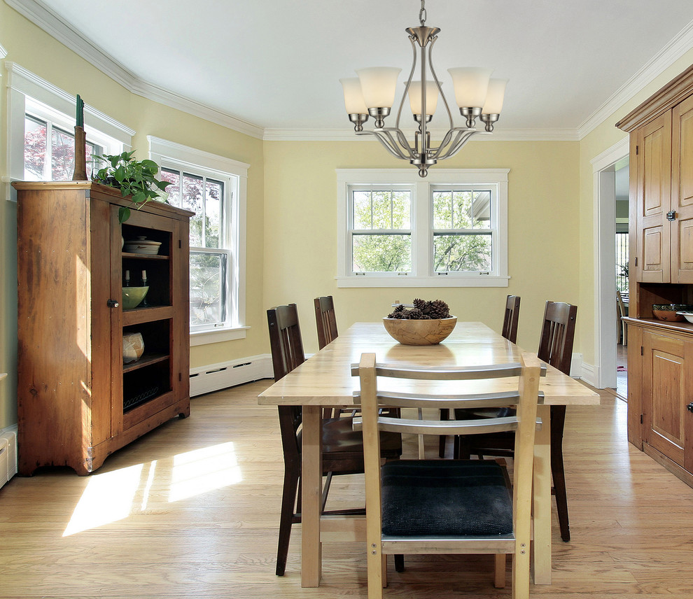 Photo of a medium sized classic enclosed dining room in New York with yellow walls, medium hardwood flooring and no fireplace.