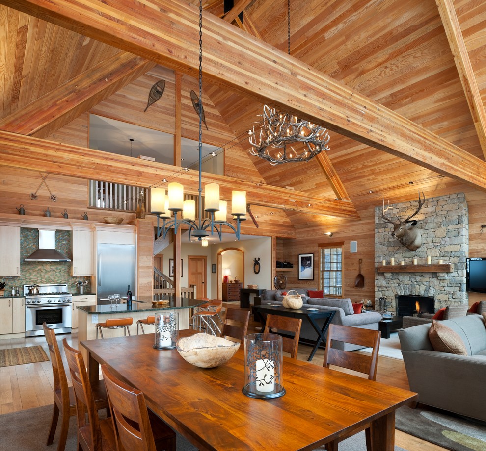 Aménagement d'une salle à manger ouverte sur le salon montagne avec un sol en bois brun.