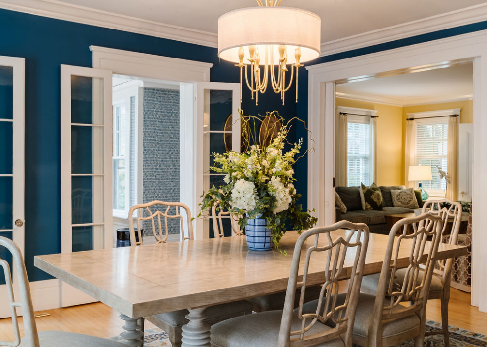 Inspiration pour une salle à manger traditionnelle avec un mur bleu et parquet clair.