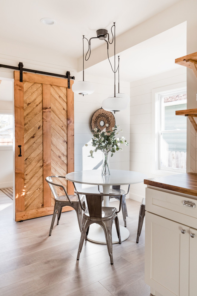 Imagen de comedor de cocina de estilo de casa de campo pequeño con paredes blancas, suelo laminado y suelo gris
