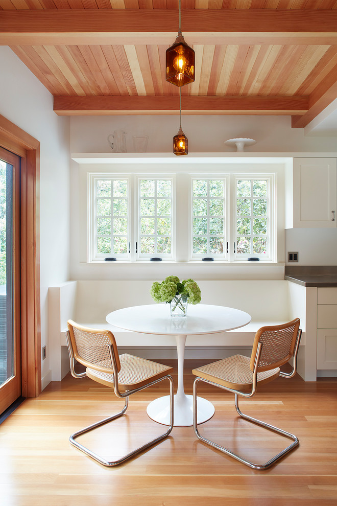 Inspiration pour une salle à manger ouverte sur la cuisine traditionnelle avec un mur blanc, un sol en bois brun et un sol marron.