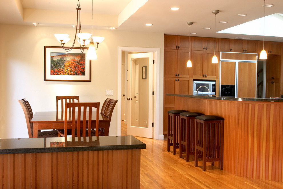 Immagine di una grande sala da pranzo aperta verso la cucina contemporanea con pareti beige, pavimento in legno massello medio e nessun camino