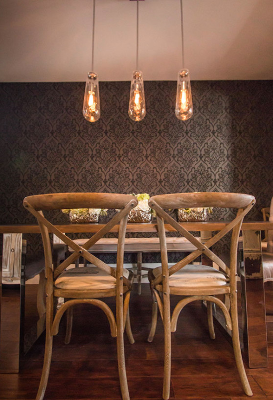 Cette image montre une salle à manger ouverte sur le salon traditionnelle de taille moyenne avec un mur gris, parquet foncé et aucune cheminée.