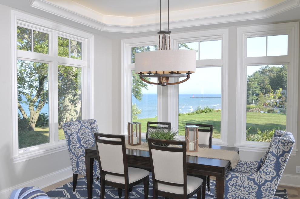 Idee per una grande sala da pranzo aperta verso il soggiorno stile marino con pareti beige e parquet chiaro