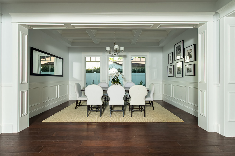 This is an example of a large nautical enclosed dining room in Los Angeles with white walls, dark hardwood flooring and no fireplace.