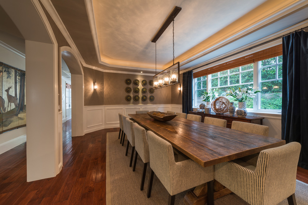 Cette image montre une salle à manger traditionnelle avec un mur marron et parquet foncé.