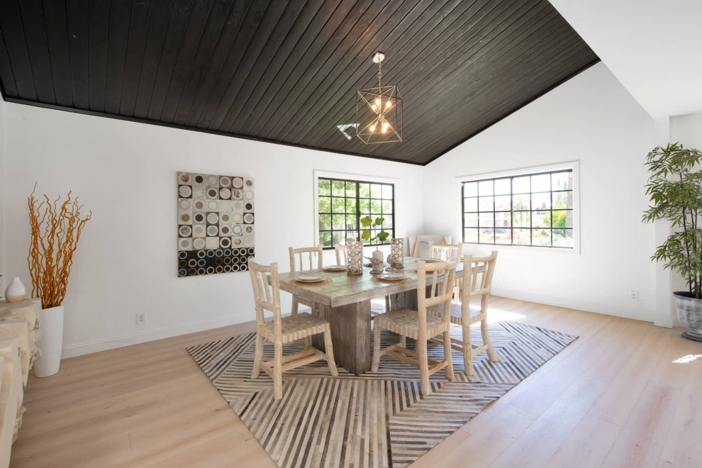 Ispirazione per una grande sala da pranzo aperta verso la cucina moderna con pareti bianche, parquet chiaro e soffitto in perlinato