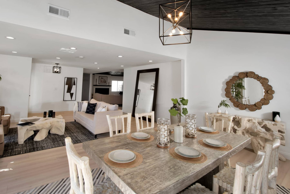 Idee per una grande sala da pranzo aperta verso la cucina moderna con pareti bianche, parquet chiaro e soffitto in perlinato