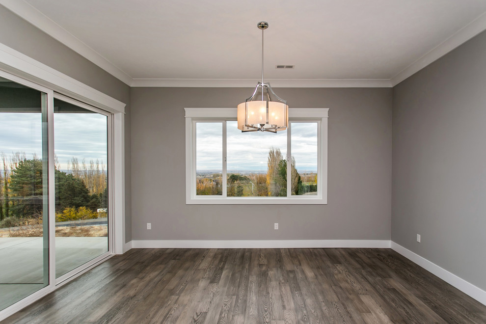 Aménagement d'une salle à manger ouverte sur le salon classique de taille moyenne avec un mur gris, un sol en bois brun, aucune cheminée et un sol gris.