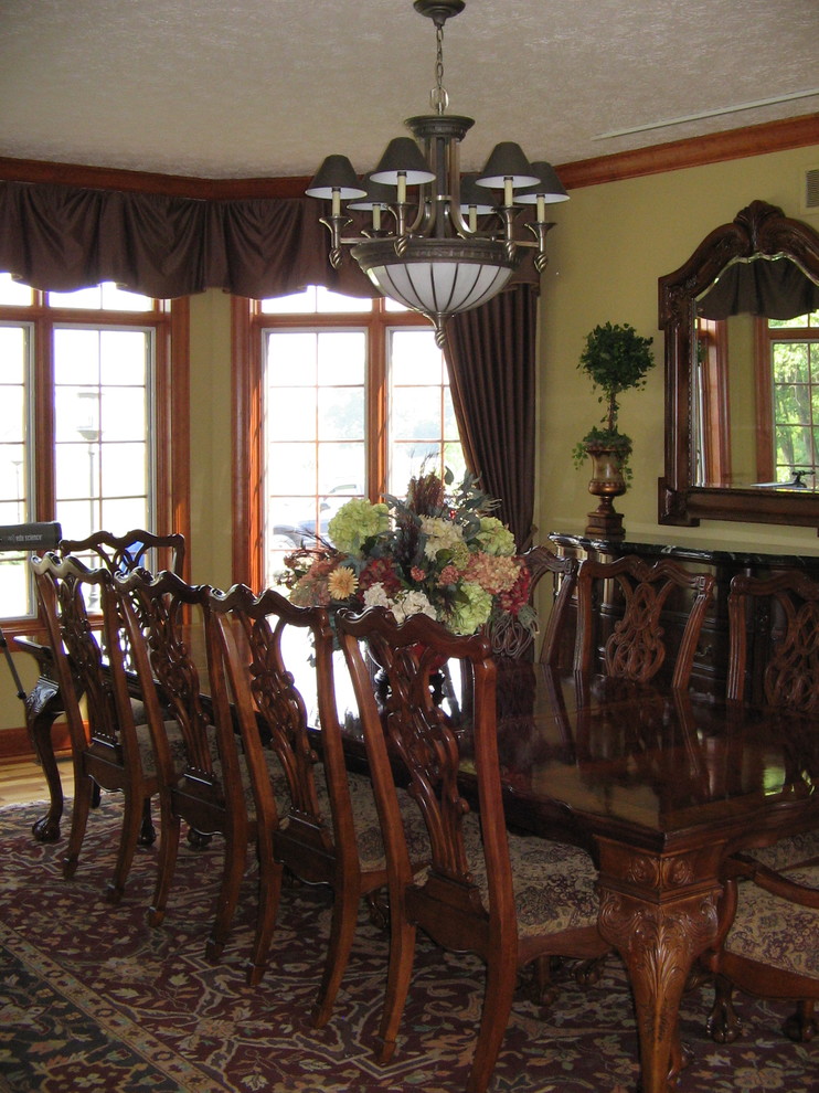 Пример оригинального дизайна: столовая в классическом стиле с желтыми стенами и паркетным полом среднего тона