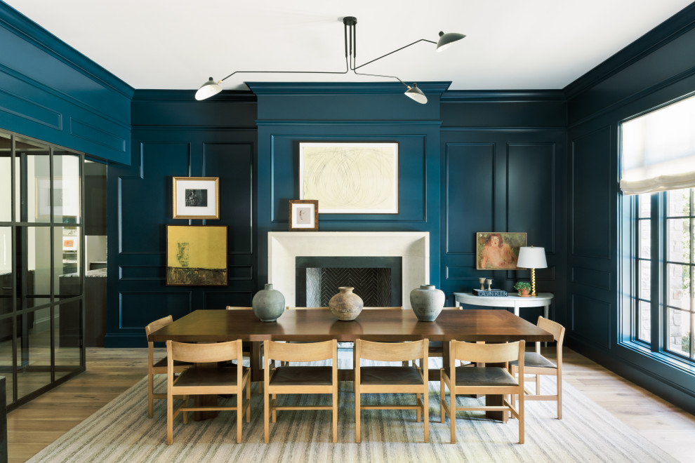Идея дизайна: столовая в стиле неоклассика (современная классика) с синими стенами, светлым паркетным полом и стандартным камином