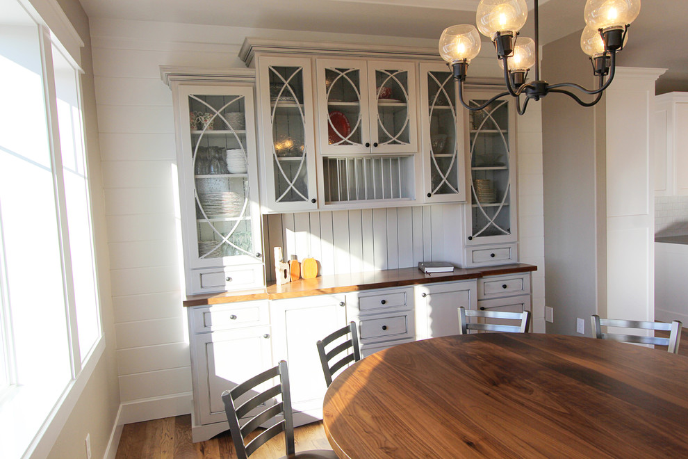 Idée de décoration pour une salle à manger ouverte sur la cuisine champêtre de taille moyenne avec un mur blanc et un sol en bois brun.