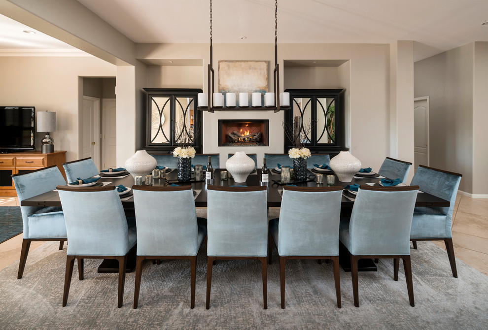 This is an example of a medium sized classic kitchen/dining room in Phoenix with grey walls, travertine flooring, a standard fireplace, a plastered fireplace surround, beige floors and feature lighting.