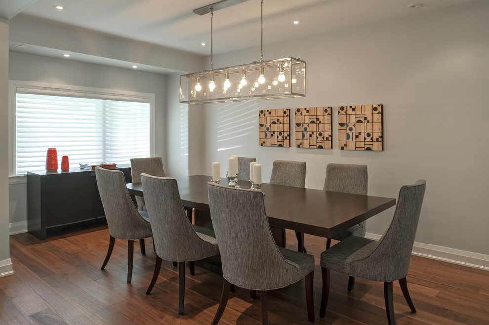 Photo of a large modern kitchen/dining room in Toronto with grey walls, medium hardwood flooring and brown floors.