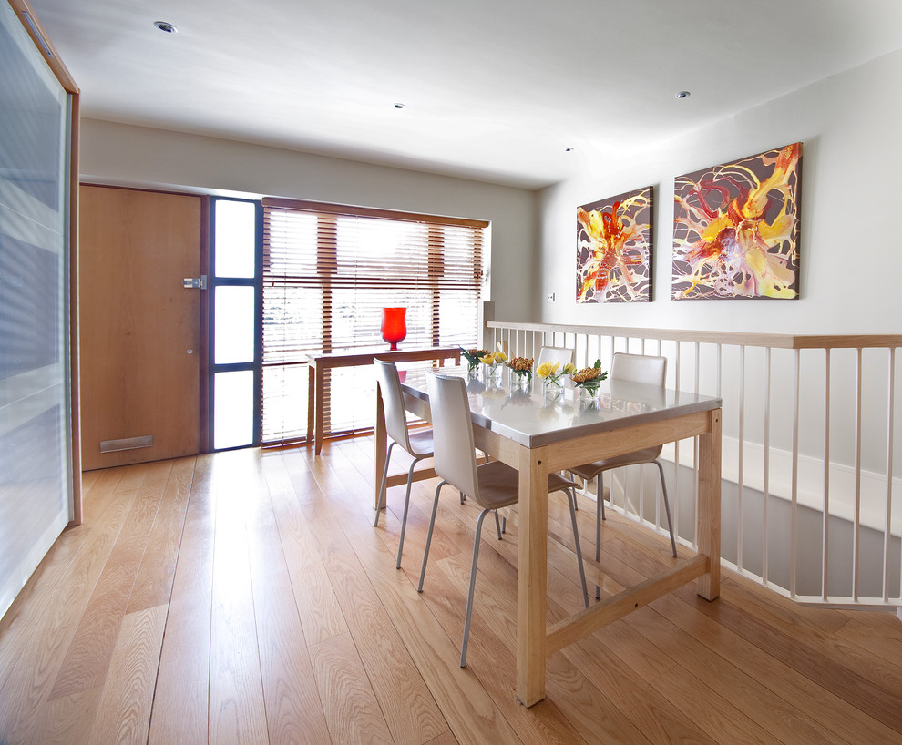 Inspiration for a small contemporary dining room in London with grey walls, light hardwood flooring and no fireplace.