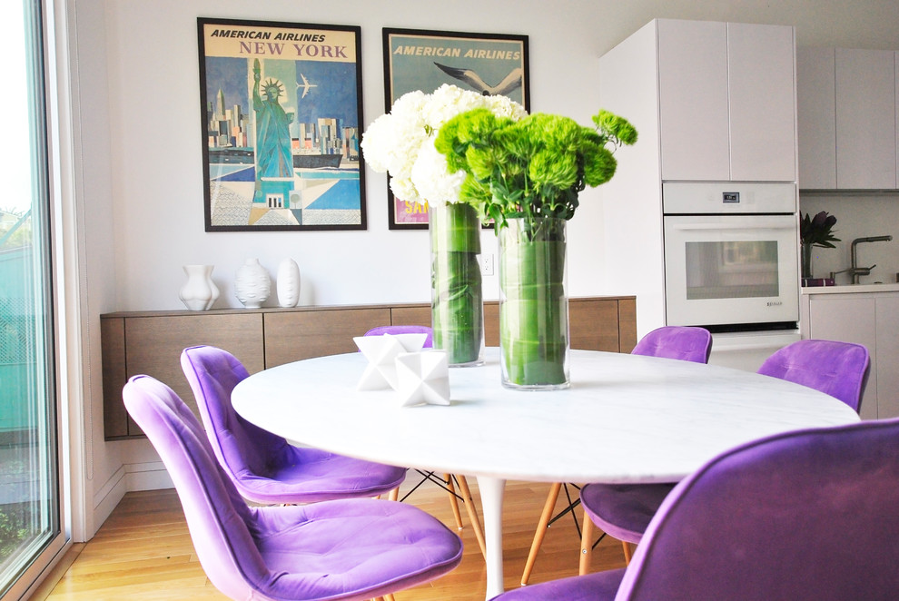 Foto di una piccola sala da pranzo aperta verso la cucina minimal con pareti bianche, pavimento in legno massello medio e pavimento marrone
