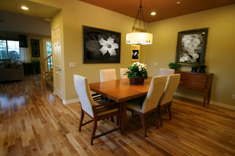 Mid-sized minimalist light wood floor and brown floor enclosed dining room photo in Denver with yellow walls