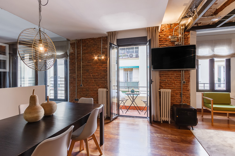 Offenes, Mittelgroßes Industrial Esszimmer mit braunem Holzboden in Madrid