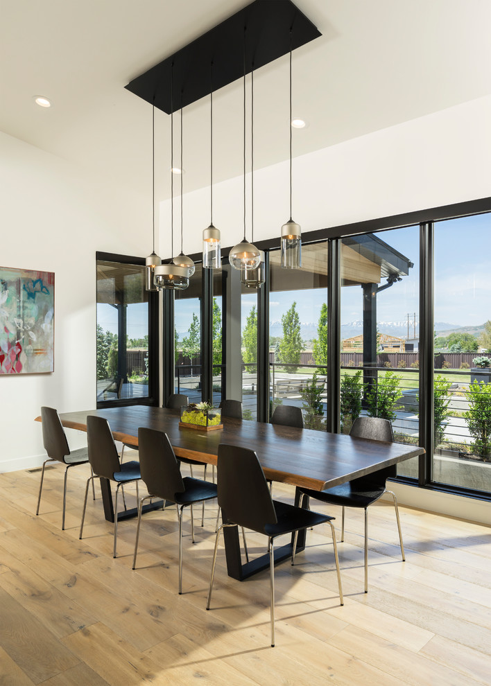 Expansive contemporary dining room in Salt Lake City with white walls, light hardwood flooring and beige floors.