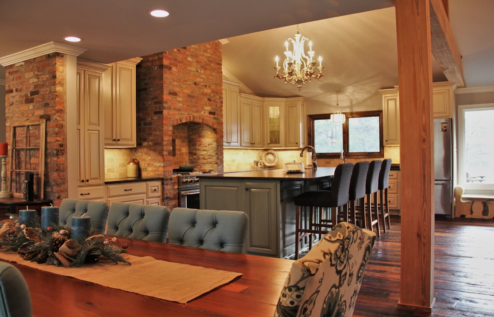 Foto di una sala da pranzo aperta verso la cucina rustica di medie dimensioni con pareti beige, parquet scuro e pavimento marrone
