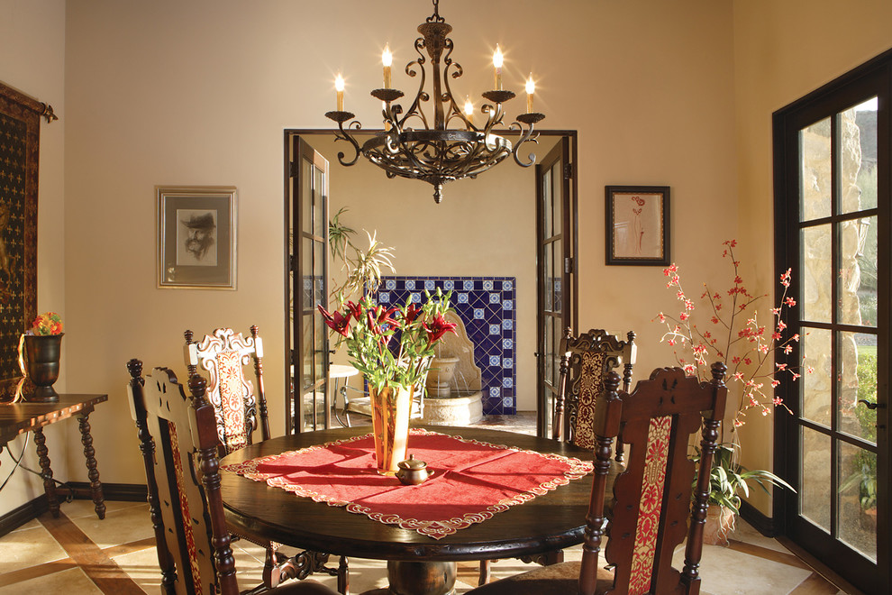 Immagine di una grande sala da pranzo aperta verso la cucina tradizionale con pareti beige e pavimento in pietra calcarea