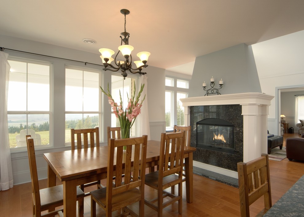 Стильный дизайн: кухня-столовая среднего размера в современном стиле с синими стенами, паркетным полом среднего тона, двусторонним камином и фасадом камина из плитки - последний тренд