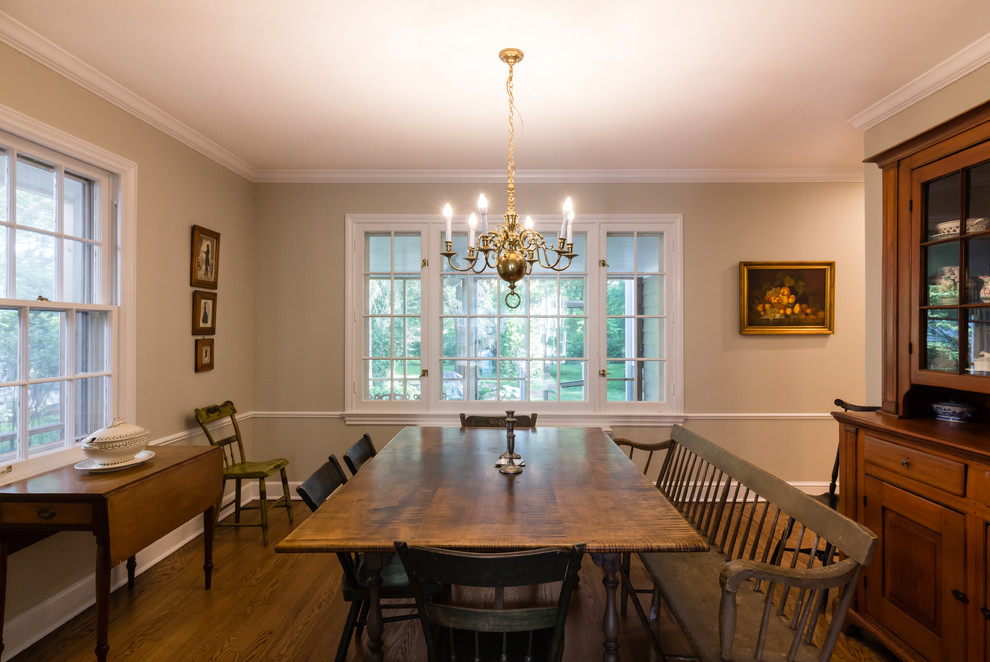 Cette image montre une salle à manger traditionnelle fermée avec un mur beige, un sol en bois brun, aucune cheminée et un sol marron.